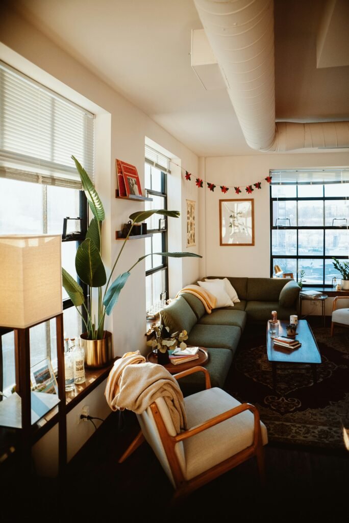 Cozy apartment living room with layered throws, textured rug, upholstered seating, and natural wood accents